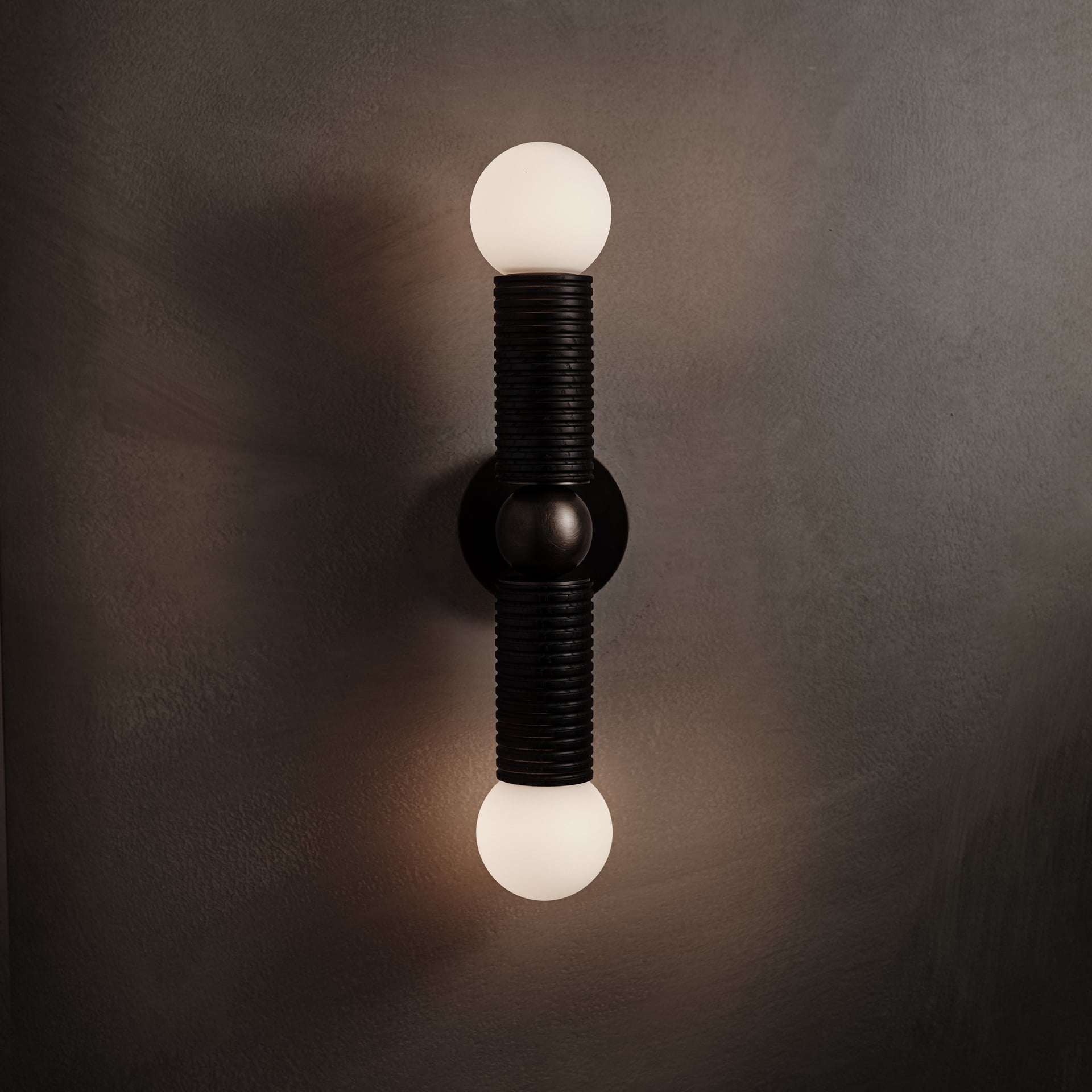 Axis Wall Sconce in ebonized and brown wax polished, lit, Studio Baldo