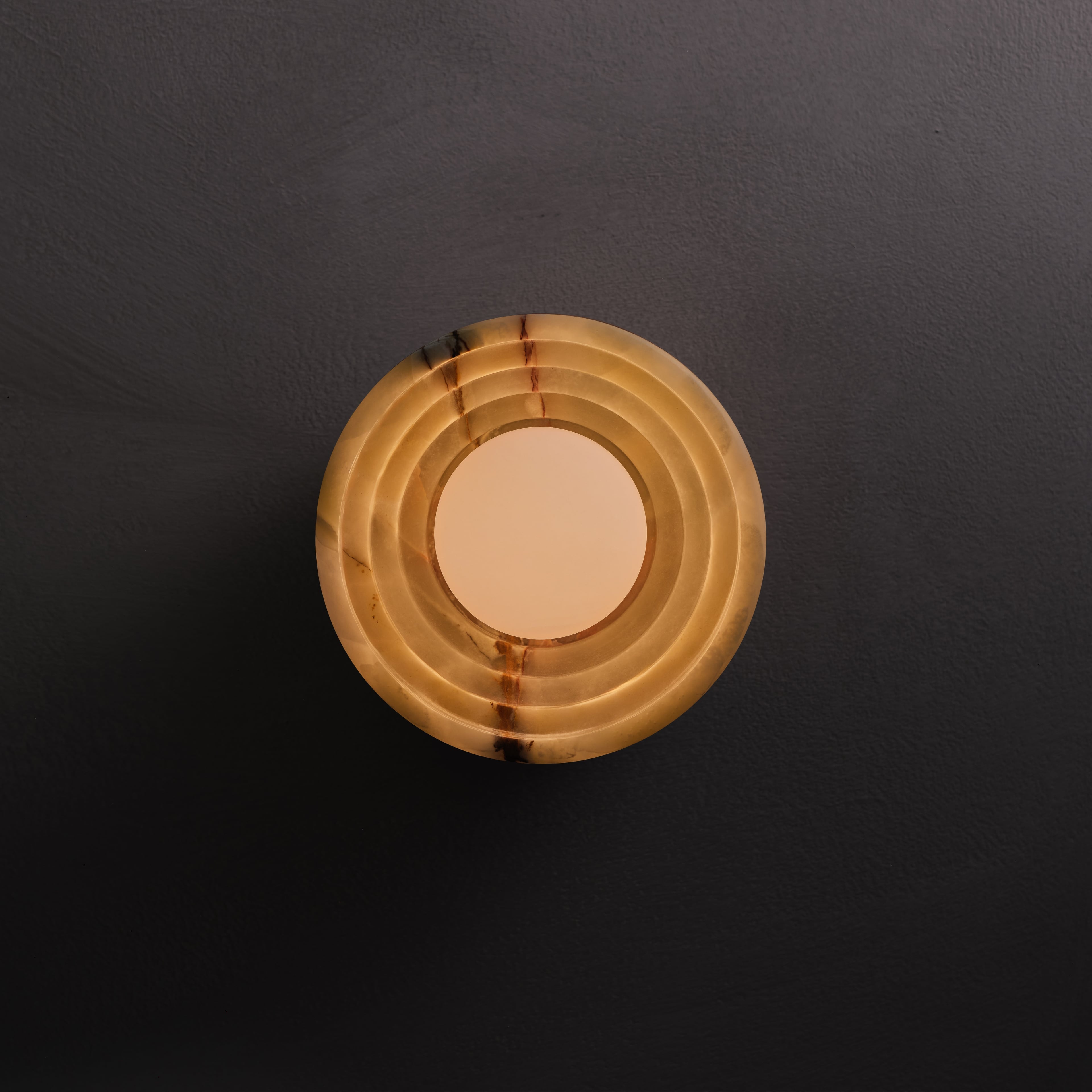 Bruma Wall Sconce in Green Onyx and aged brass, lit, Studio Baldo