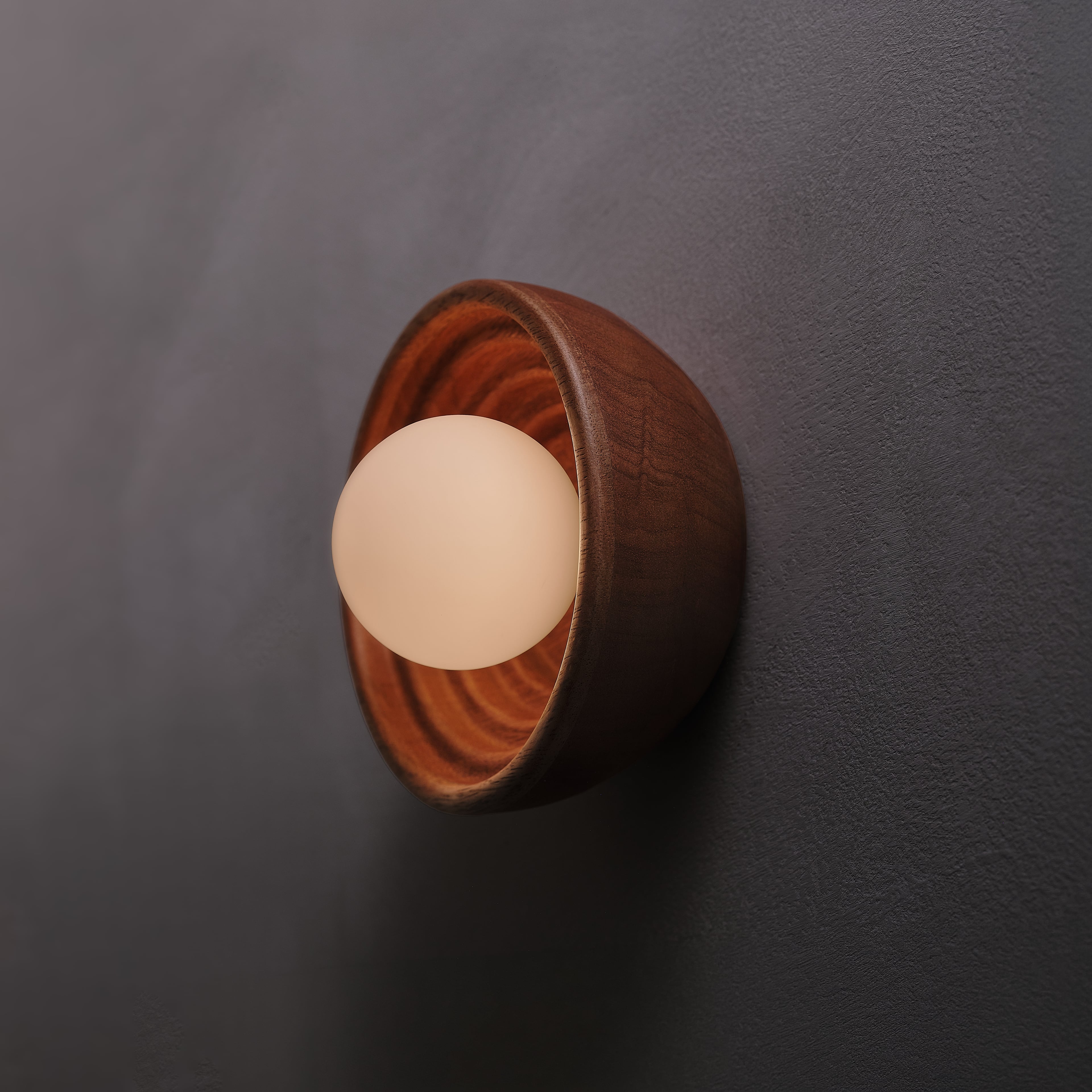 Bruma Wall Sconce in seike and aged brass, angled view, lit, Studio Baldo