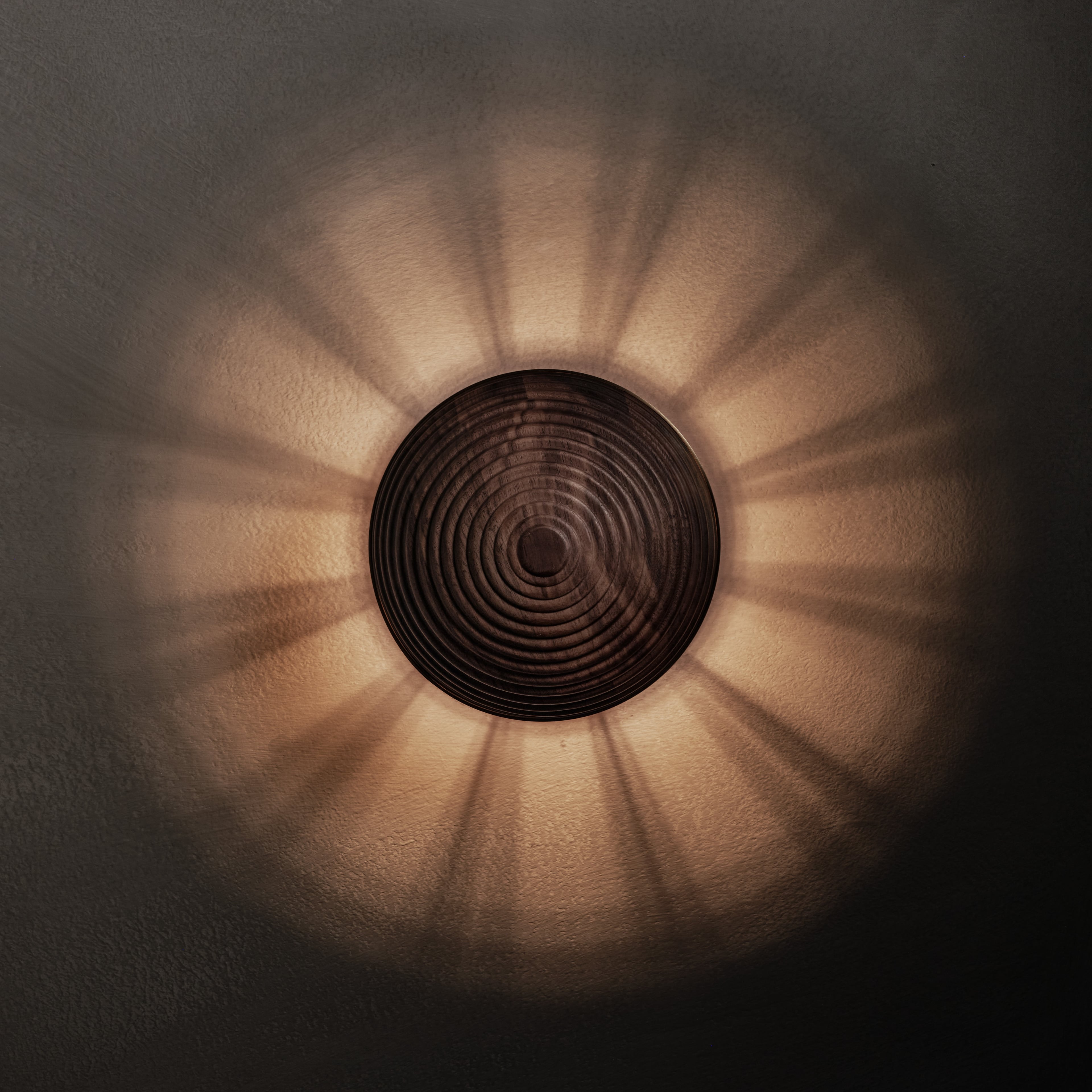 Contour Wall Sconce in walnut and aged brass, lit, Studio Baldo