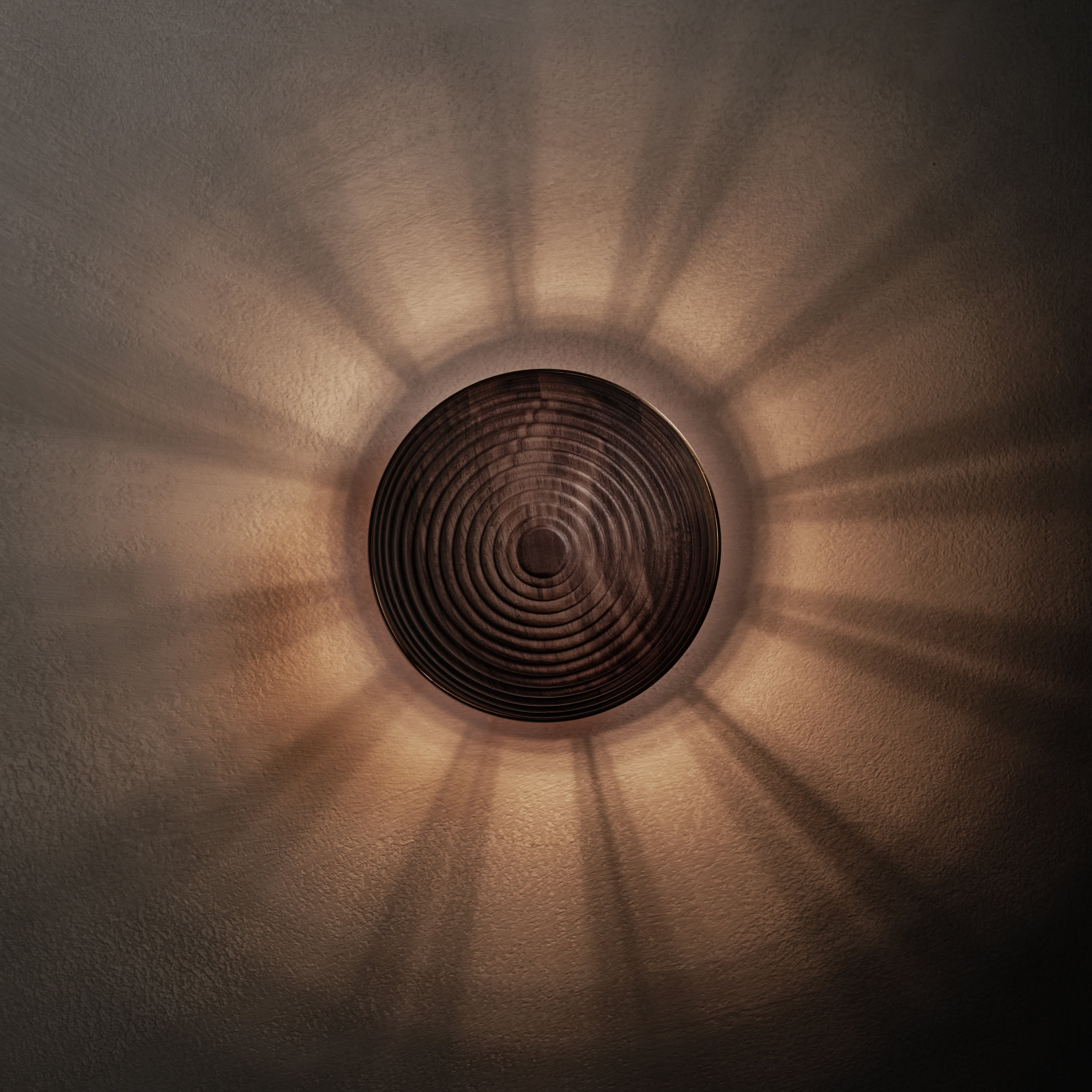 Contour Wall Sconce in walnut and aged brass, lit, Studio Baldo