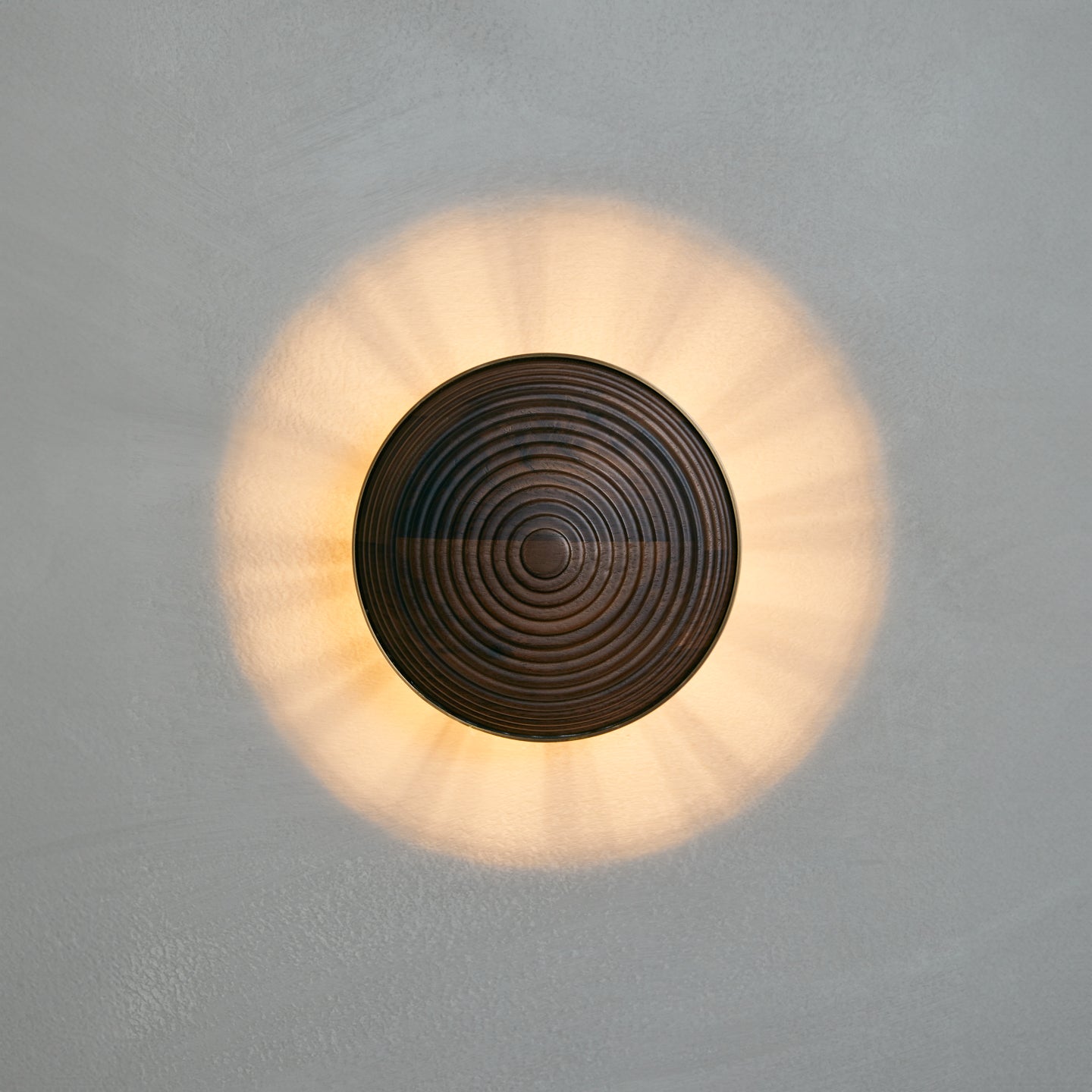 Contour Wall Sconce in walnut and aged brass, lit, Studio Baldo